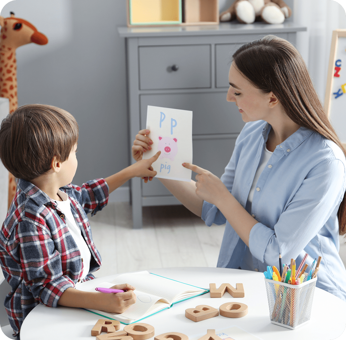 Child learning letters with teacher