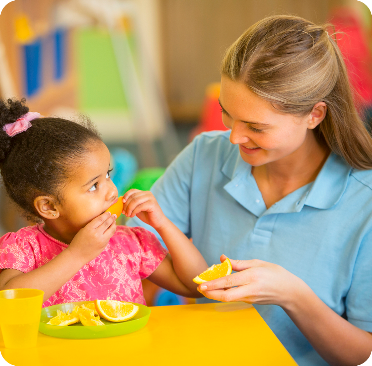 Teacher and child sharing orange slices