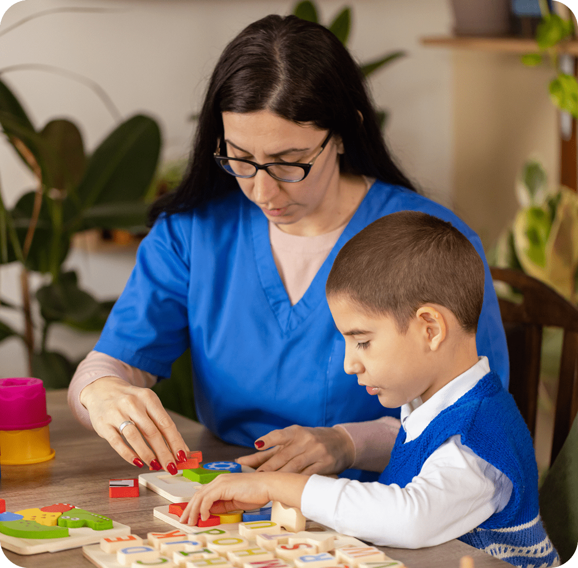 Educator helping kid with colorful blocks